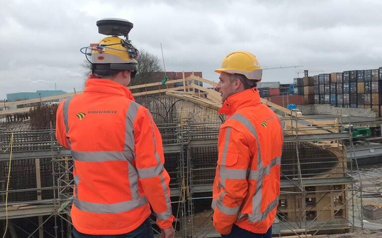 constructor con casco y planos en obra