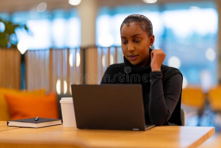 estudiante usando laptop en biblioteca moderna