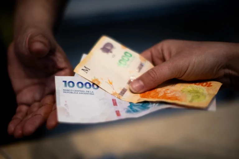 manos sosteniendo bonos financieros argentinos