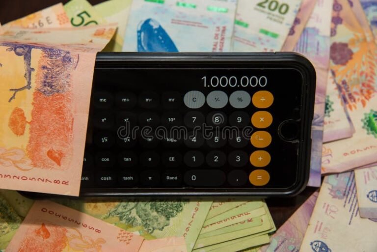 moneda argentina y calculadora sobre mesa